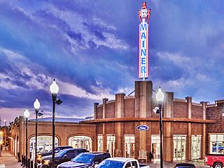Neon sign Mainer Ford dealership Bristow Route 66 retro looking neon sign atop auto dealership at night lit up