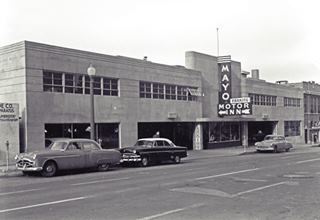 1950s photo Mayo Motor Inn 1950s black and white photo. Cars parked by a garage with neon sign and curve lines on facade. reads Mayo Motor Inn