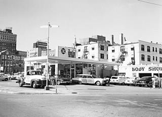 McGee D-X station Tulsa c1960 cars at a DX gas station, garage bays on the right, buildings beyond. Black and white photo