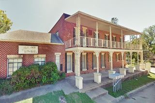 former Mendenhall Bath House Claremore picture of a two story building with balcony and flat roof