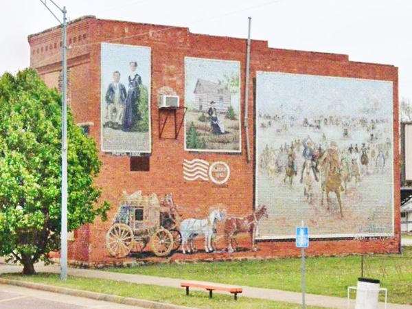 mural depicting the Land Run of 1891 on the red-brick wall of a bank