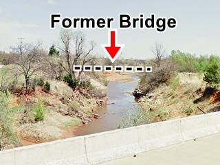 site of former Deep Fork River Bridge river, steep banks and remains of old bridge abutements