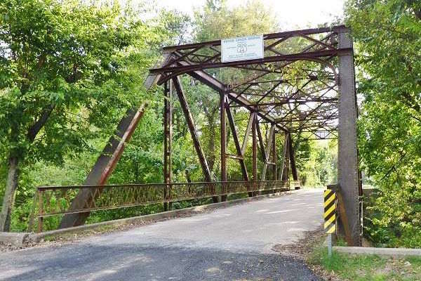 steel bridge on narrow road among trees