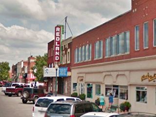 current view with cars, buildings and Redland Theater