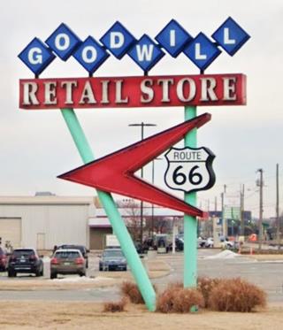 Goodwill Store neon sign Tulsa US66 Slender poles hold up a red boomerang arrow with a US66 shield topped by a red panel with RETAIL STORE written in it topped by blue rhombus panels with white letters spelling GOODWILL