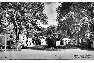 Shady Rest Motel black and white postcard 1940s, car parked, shady area surrounded by trees and a motel U-layout