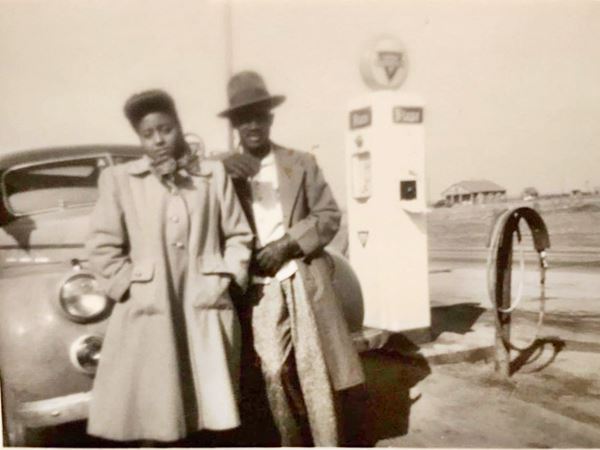 Black couple c.1950s, gas pumps and car