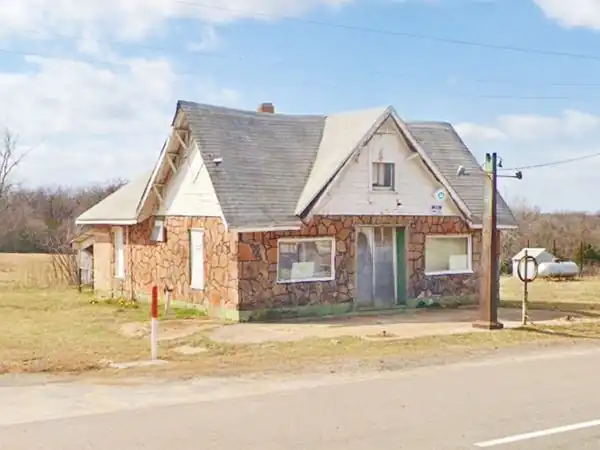 Threatt gas station in 2021 rock building, cross gabled roof: historic Threatt filling station