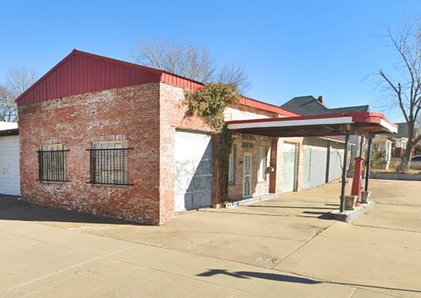 BF Goodrich - Phillips 66 gas station Tulsa US66 brick 1 story box shaped old gas station, add-on tin gable roof. Flat tin canopy, over pump island decorated with old 1930s pump, wide paved drive area