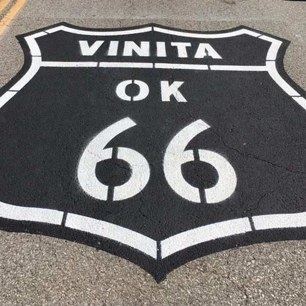 large US 66 highway shield in black and white letters painted on the asphalt
