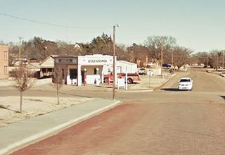 old 1930s Magnolia gas station on a corner and a red-brick paved road leading to it