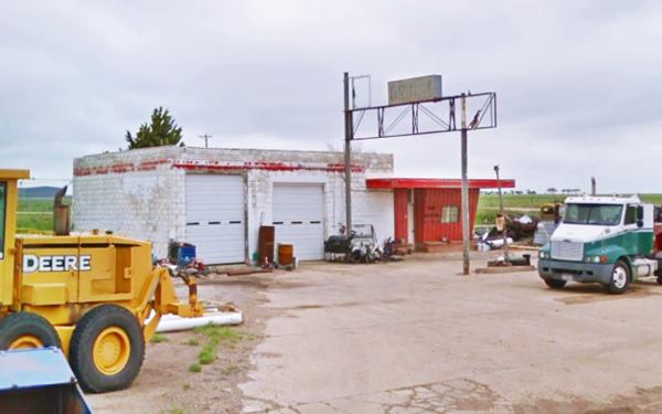 abandoned gas station, in ruins with scrap and old vehicles