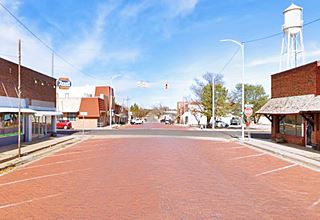 Main St. paved with bricks meets US 66, buildings and beyond the water tank