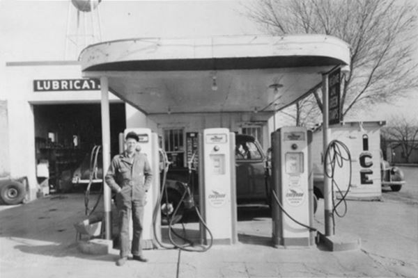 black and white photo, gas station in the 1940s with attendant