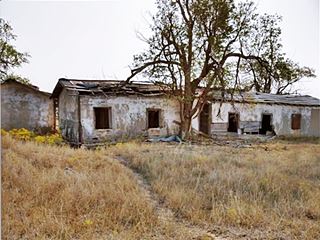 Jericho tourist court by Jericho-on-66 abandoned and ruined one floor motel building in field
