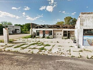 McLean's Texas gas station nowadays ruined and decaying one story corner building with garage bays