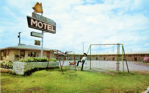 Motel with classic neon sign in a color vintage postcard
